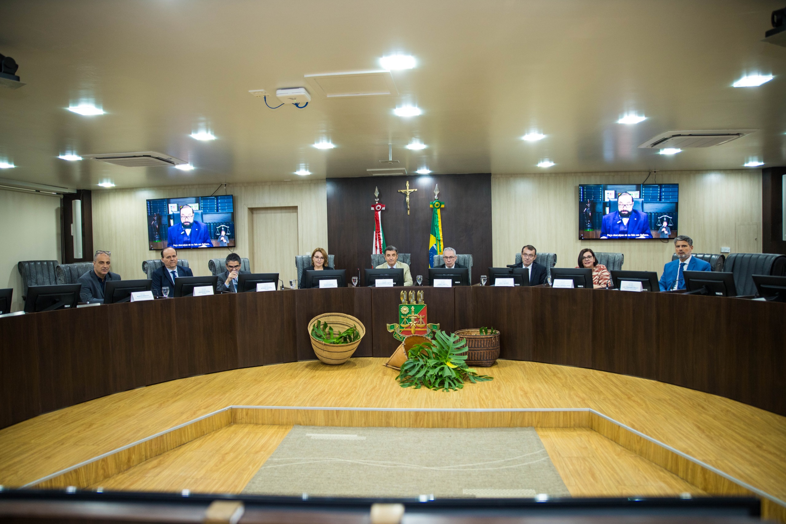 Foto colorida em plano aberto mostrando a mesa do pleno