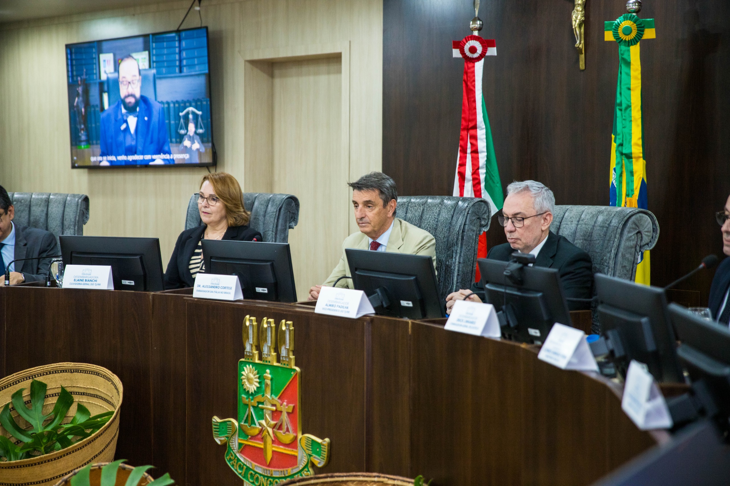 Foto colorida dando destaque Alessandro Cortese ao lado do Desembargador Almiro Padilha, Desembargadora Elaine Bianchi.