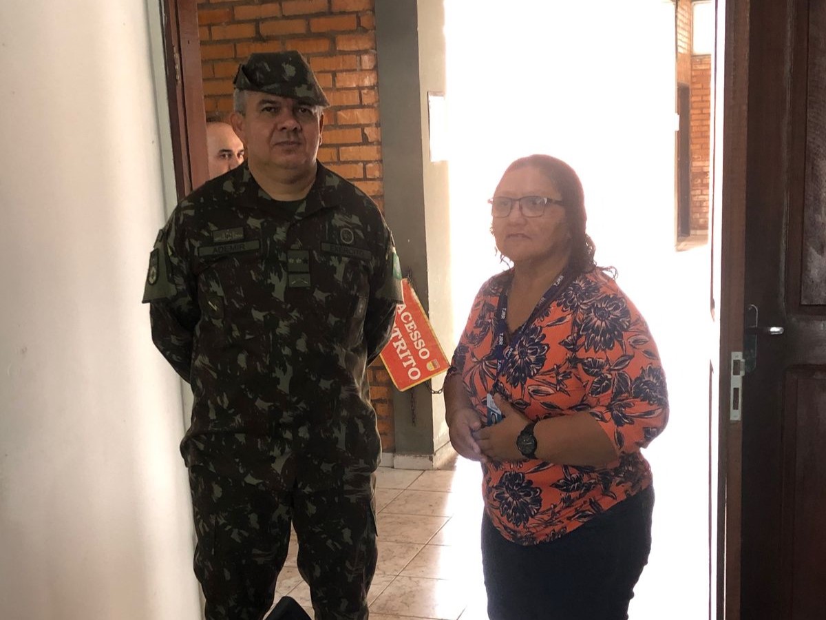 Foto colorida de uma servidora ao lado do Tenente-Coronel Ademir Rodrigues Oliveira