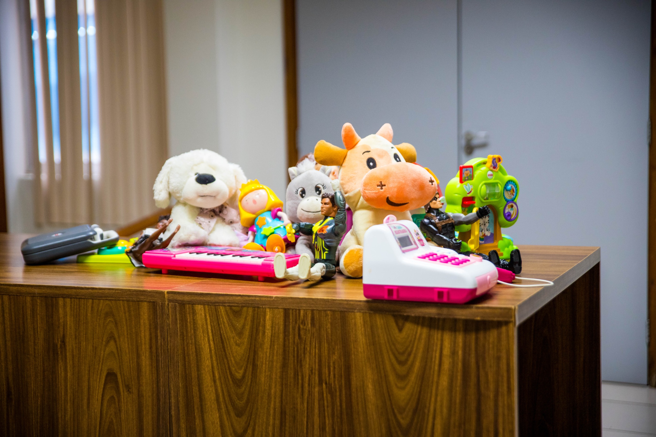 foto colorida de uma mesa cheia de brinquedos e ursinhos de pelúcia.